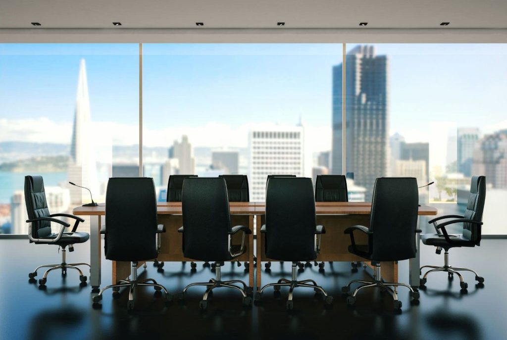 Sala de juntas corporativa moderna, representando a una gran empresa que utiliza los planes Enterprise de Microsoft 365 para seguridad y cumplimiento.
